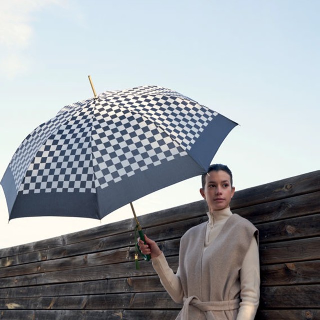Damski parasol w szachownicę w dłoni eleganckiej kobiety.