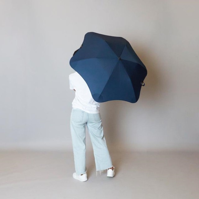 Granatowy parasol Blunt nad głową mężczyzny.